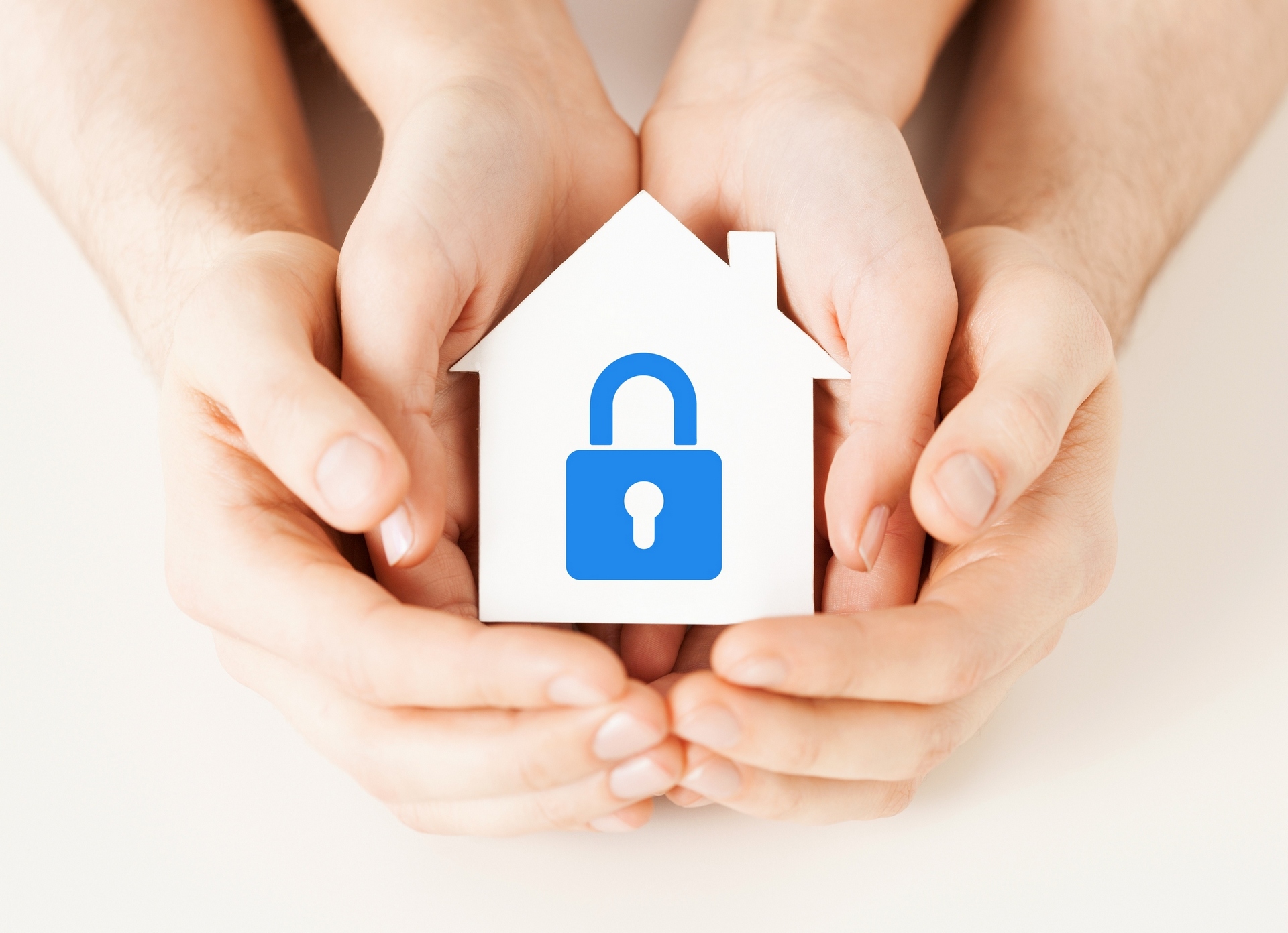 hands holding paper house with lock