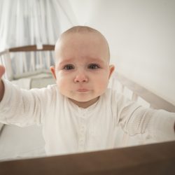 small abandoned baby in the crib crying